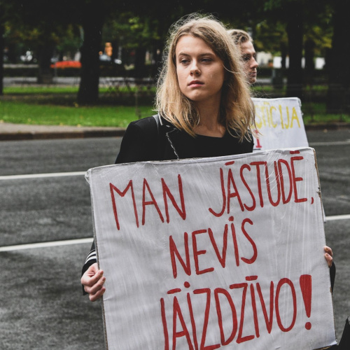 Foto no protesta akcijas "Klusuma brīdis augstākajai izglītībai", ko organizēja Latvijas Studentu apvienība. Attēlā attēlota meitene, kas tur rokās plakātu ar vēstījumu "MAN JĀSTUDĒ, NEVIS JĀIZDZĪVO". Protests norisinās lietainā laikā uz ielas pretim Ministru kabinetam Rīgā.

Foto autore: Izabella Rumkovska